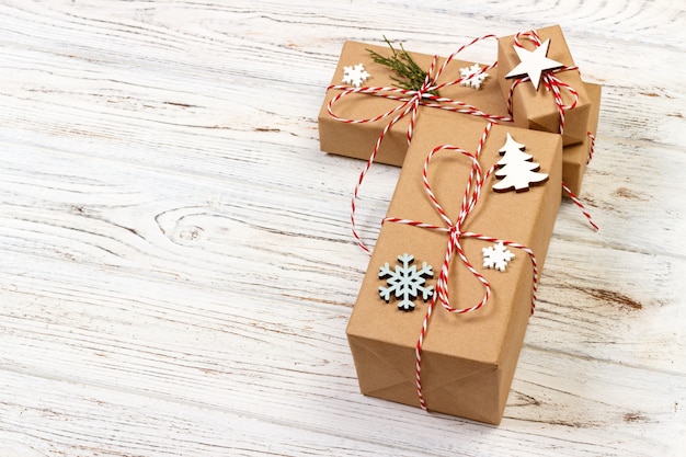 Christmas gift box decorated by snowflake on wooden background