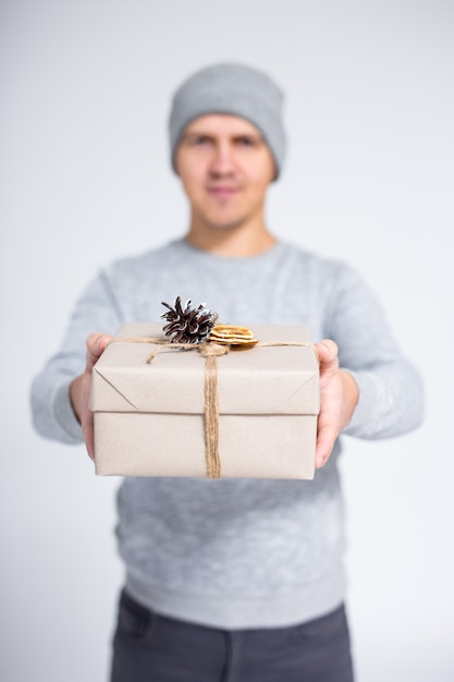 회색 배경 위에 남성 손에 크리스마스 선물 상자
