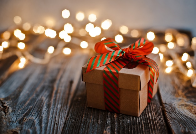 Christmas gift box lay wooden table  bokeh  festive lights.