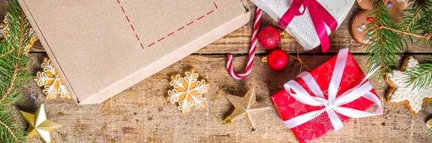 https://img.freepik.com/premium-photo/christmas-gift-box-package-gift-exchange-christmas-new-year-concept-on-covid-19-pandemic-secret-santa-post-game-packing-gifts-cookies-in-parcel-wooden-background-with-xmas-tree-branch-and-decor_136595-19752.jpg