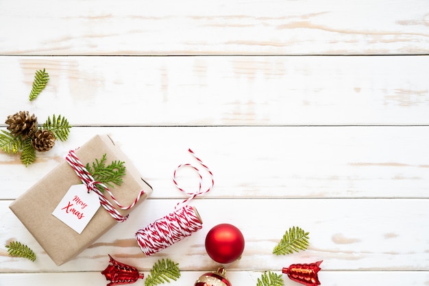 Christmas gift box, pine cones, red star and bell on a wooden background.