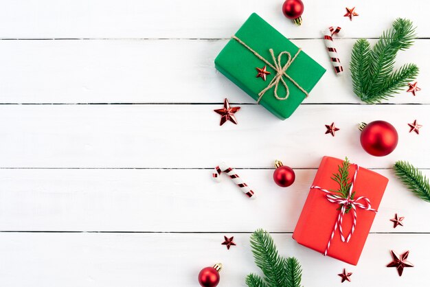 Christmas gift box, spruce branches, red ball on wooden background