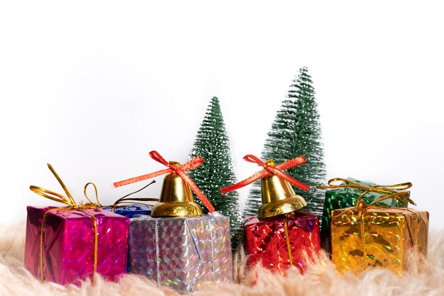 Christmas gift box and tree with golden bells, pine cones, red and white ball