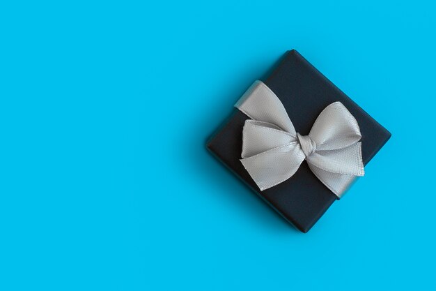 Christmas gift box with bow on blue background, for mockup or design, place for copyspace