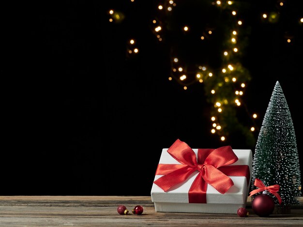 Christmas gift box with decorations on wooden table, space for text