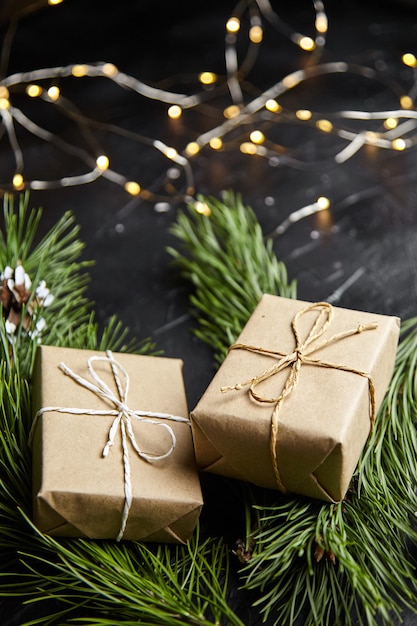 Christmas gift box with light garland on dark background