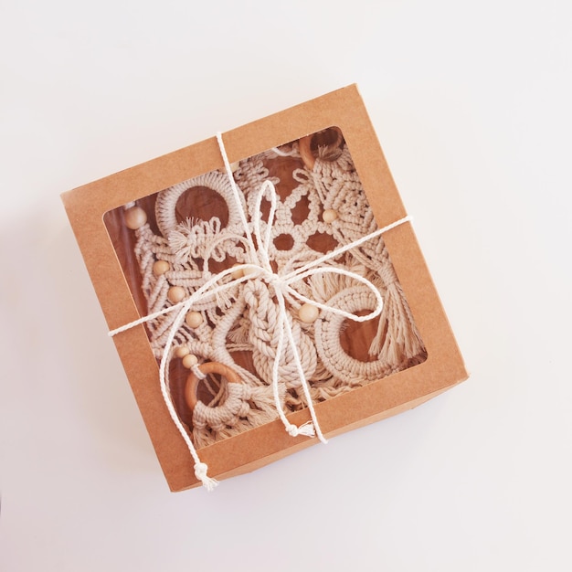 Christmas gift box with macrame decor Christmas tree ring snowflake in style of macrame Natural materials cotton thread wood beads Eco decorations ornaments hand made decor Copy space