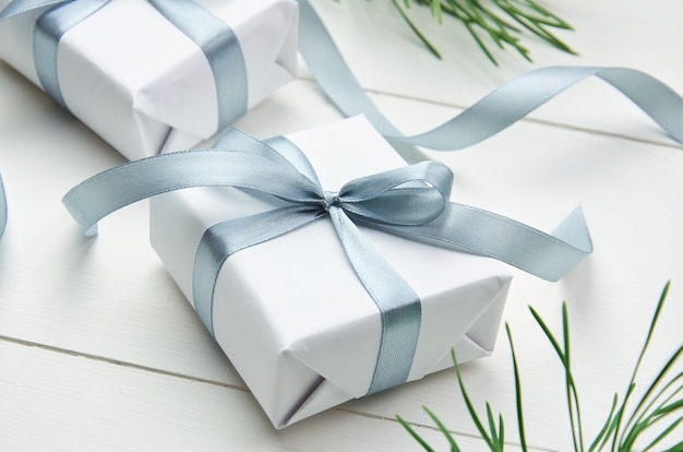Рождественская подарочная коробка с ветками сосны на белом фоне