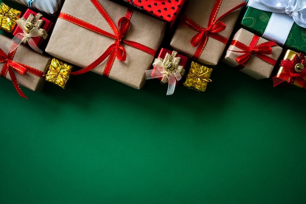 Christmas gift box with red ball on green background.