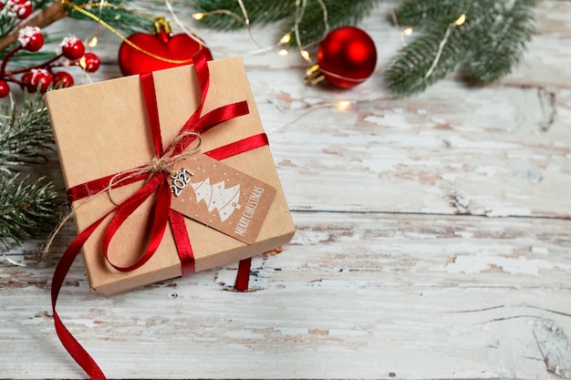 Confezione regalo di natale su uno sfondo di legno con decorazioni natalizie