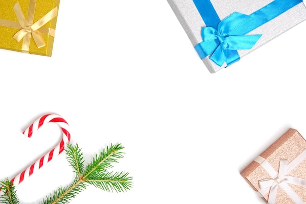 Christmas gift boxes and caramel form of a cane on white background