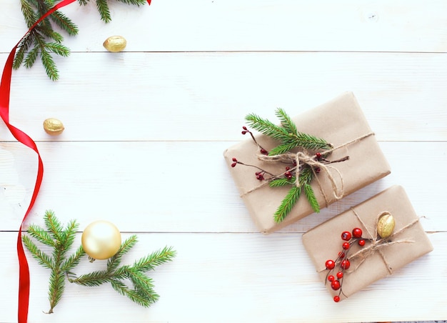 Christmas gift boxes and fir tree branch on wooden table flat lay Shristmas background