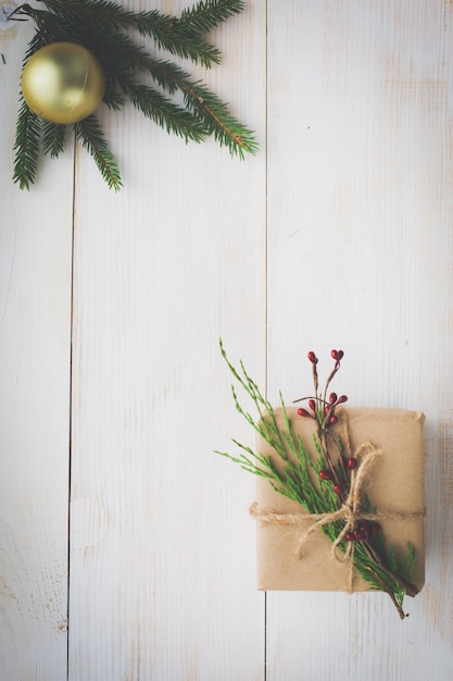 クリスマス ギフト用の箱と木製のテーブル フラットにモミの木の枝を置く Shristmas 背景