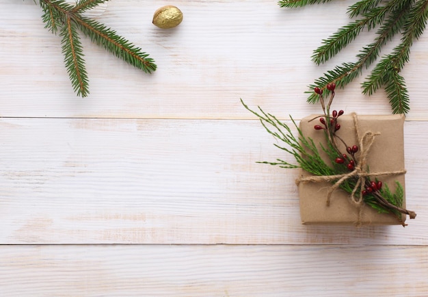 Christmas gift boxes and fir tree branch on wooden table flat lay Shristmas background