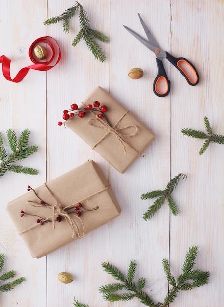 Рождественские подарочные коробки и еловая ветка на деревянном столе лежали на рождественском фоне