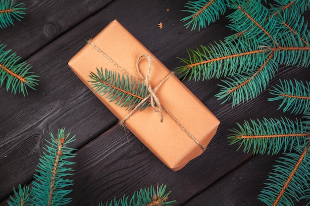 Christmas gift boxes and fir tree branch on wooden table.