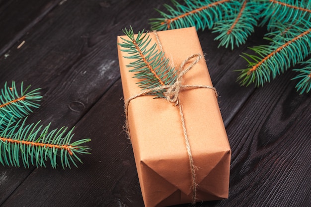 Christmas gift boxes and fir tree branch on wooden table,