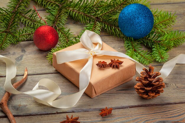 Christmas gift boxes and fir tree branch on wooden table.