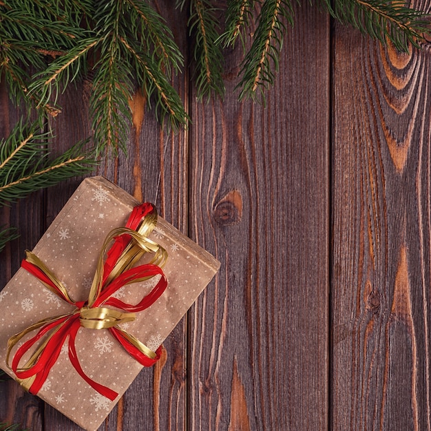 Christmas gift boxes and fir tree on wooden background