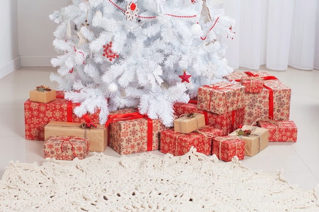 Christmas gift boxes on floor near tree