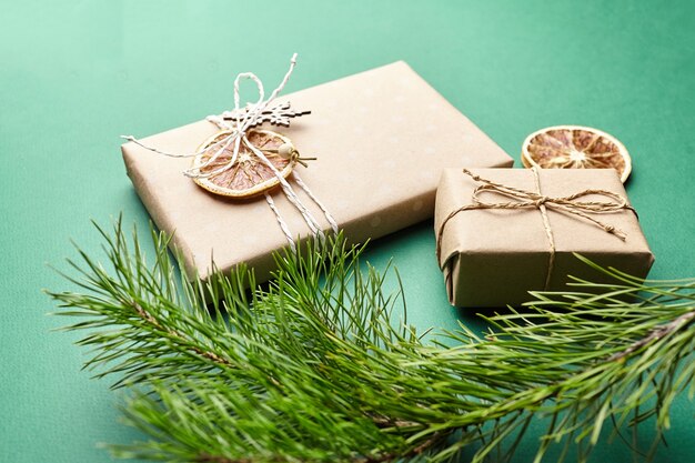 Christmas gift boxes and pine tree branches with decoration on green background