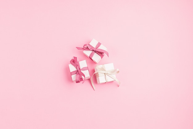 Christmas gift boxes on pink surface