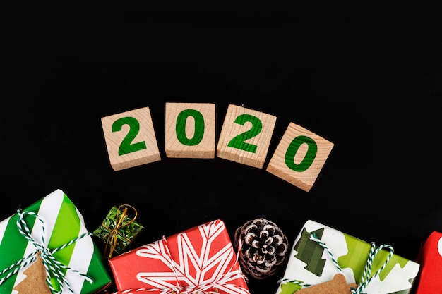 Christmas gift boxes or present and 2020 text on wooden cubes, top view