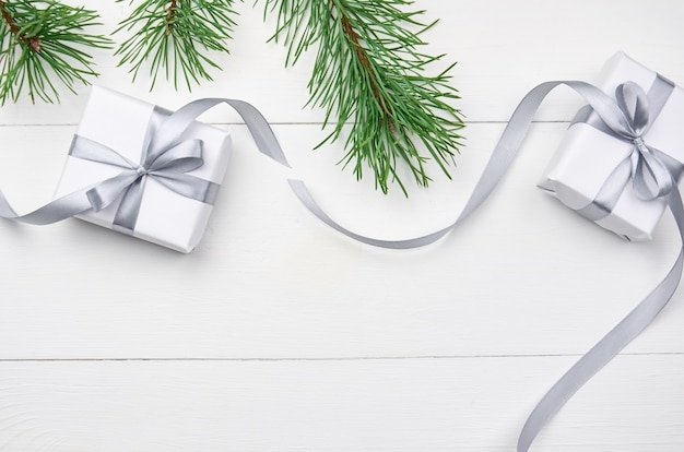 Фото Рождественские подарочные коробки с ветками сосны на белом