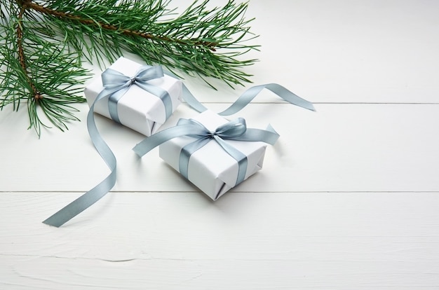 Christmas gift boxes with pine tree branches on white background