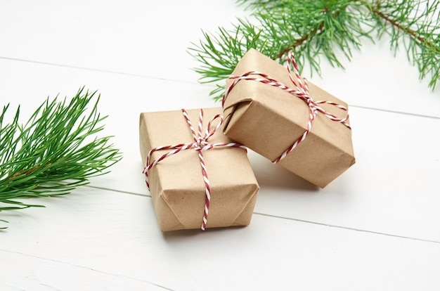 Рождественские подарочные коробки с ветками сосны на белом