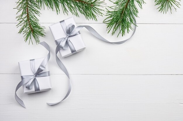 Рождественские подарочные коробки с ветками сосны на белом