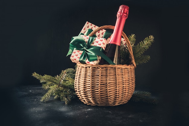 Christmas gift hamper with champagne and gift on black.