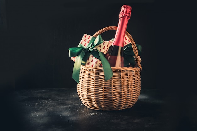 Christmas gift hamper with champagne and gift on black.