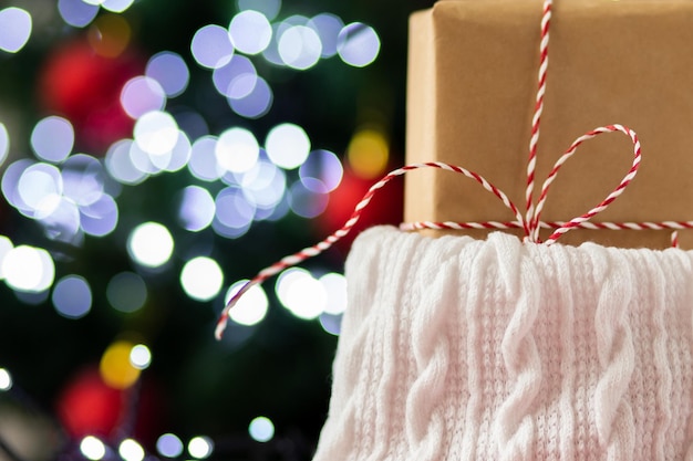 christmas gift in kraft paper in new year sock under christmas tree with sparkle bokeh lights backgroundcopy space