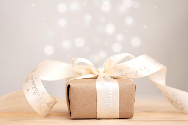 Рождество и подарок в крафт-бумаге на деревянном столе, экологически чистая концепция рождественского праздника
