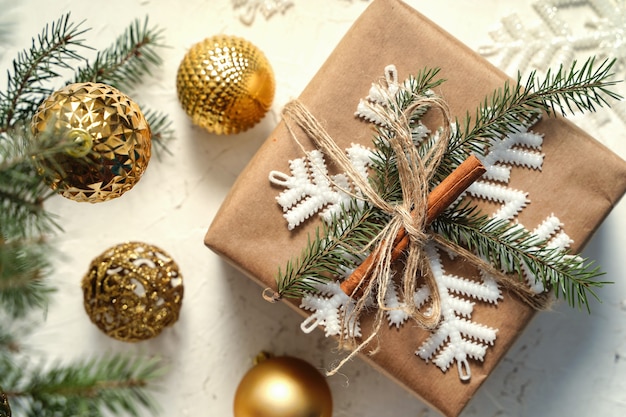 Christmas gift or present box wrapped in kraft paper with decoration on rustic white background