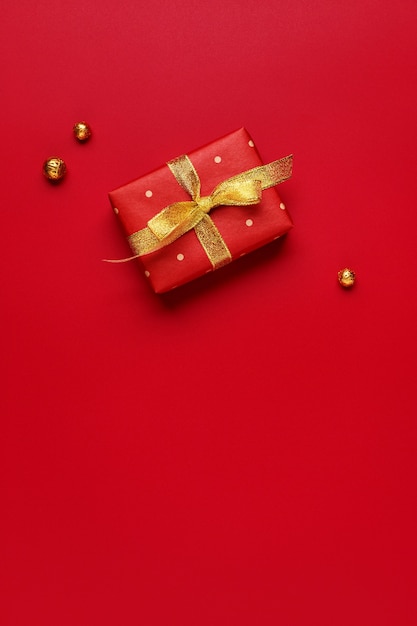 Christmas gift on red holiday background with copy space.