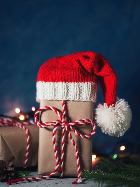 Christmas gift in Santa hat on holiday table