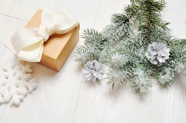  Christmas gift vintage with snow-covered branch of fir-tree on white 