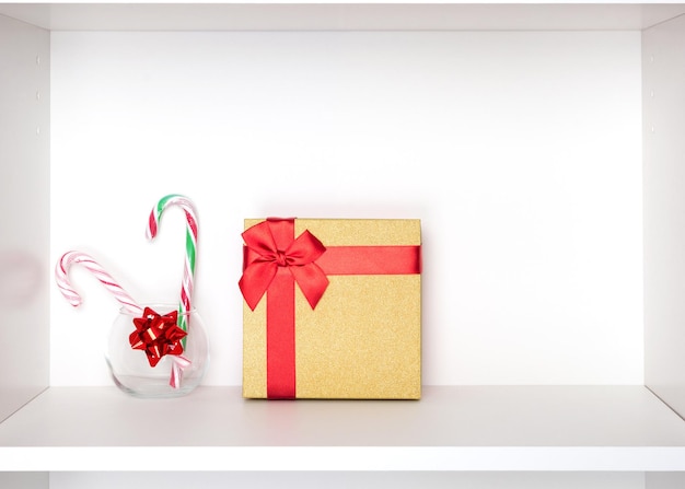 사진 흰색 캐비닛 선반에 사탕 지팡이가 있는 크리스마스 선물 휴일 준비 복사 공간