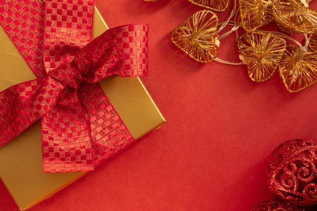 christmas gift with golden ornaments in the shape of a heart on a red background