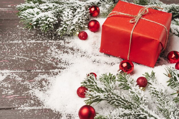 雪で覆われた木製のテーブルの上のクリスマスプレゼント