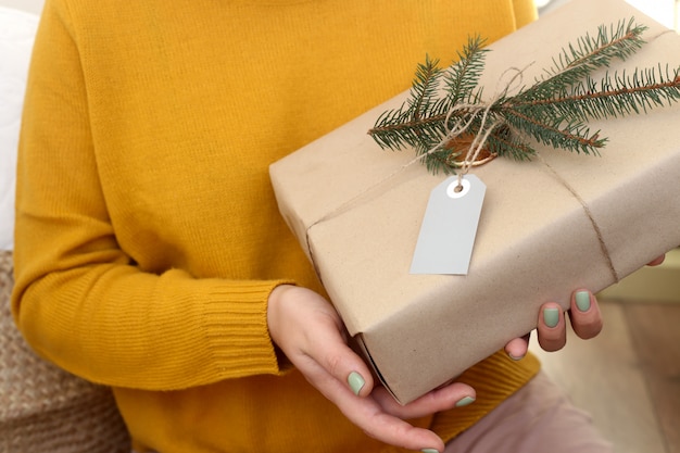 Christmas gift wrapped in craft paper decorated with gold decor