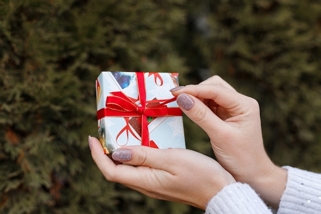 Christmas gift in your hands on a green background