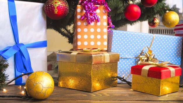 Christmas gifts boxes in wrapping paper and colorful baubles at living room