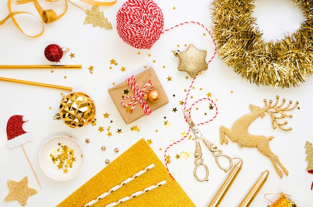 Christmas gifts and decorations in gold colors flat lay on a white background