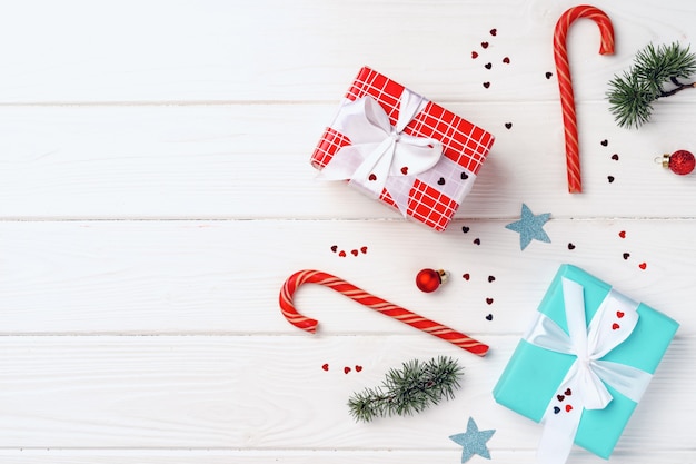 Christmas gifts and decorations on white wooden board, top view