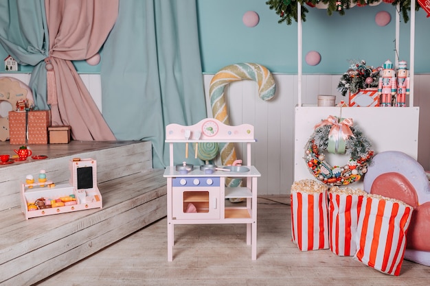 Regali di natale per bambini sotto l'albero. cucina giocattolo presente per ragazze. regalo di natale sotto l'albero. cucina e piatti in legno giocattolo.