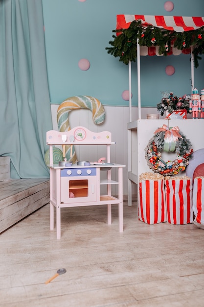 Regali di natale per bambini sotto l'albero. cucina giocattolo presente per ragazze. regalo di natale sotto l'albero. cucina e piatti in legno giocattolo.