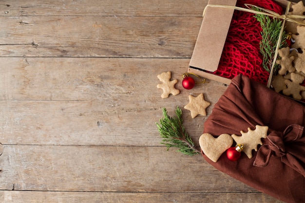 Рождественские подарки упакованы фуросики лежат на коричневом деревянном столе